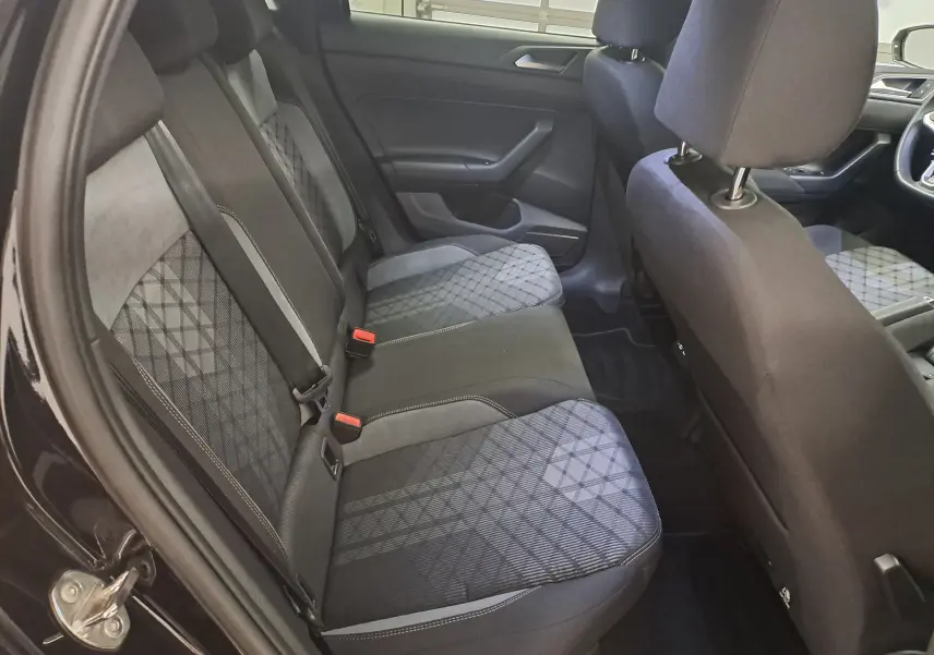 Vue intérieure côté gauche montrant la banquette arrière en tissu gris à motifs sur Volkswagen Polo Noir Intense 2025 R-Line.