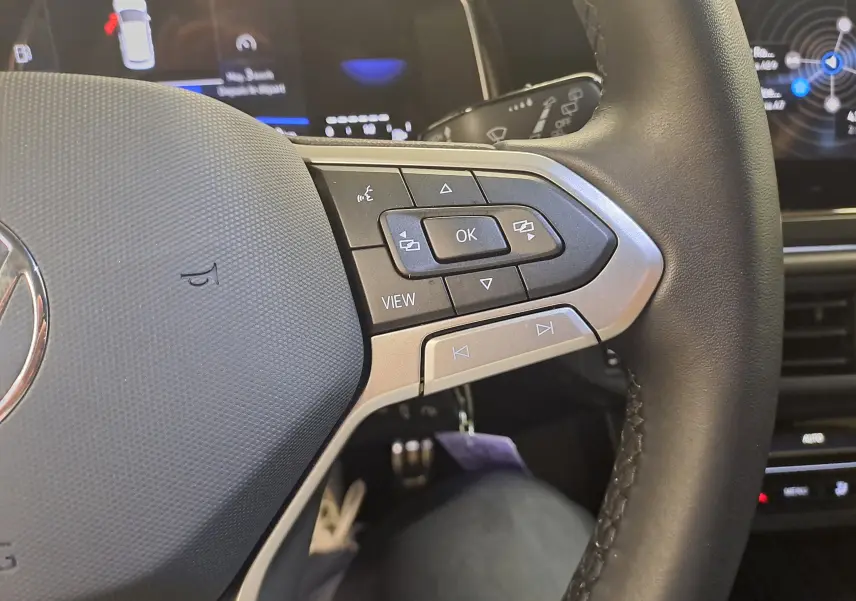Gros plan sur les commandes à droite du volant noir de la Volkswagen Polo 2025, avec écran digital en arrière-plan.