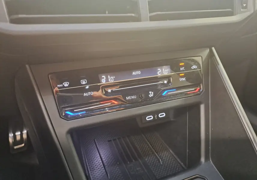 Gros plan sur la console centrale de la Volkswagen Polo 2025, affichant la climatisation automatique avec réglages numériques et ports USB.
