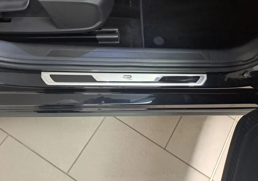 Détail de la marche d'entrée côté conducteur d'une Volkswagen Polo 2025 noir intense avec logo R visible.