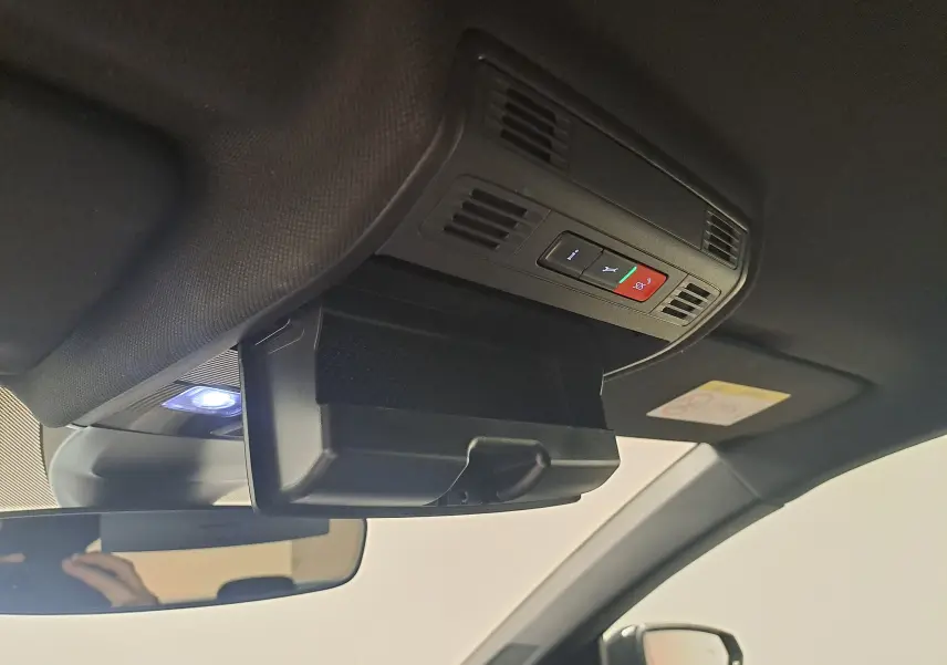 Vue intérieure du plafond de la Volkswagen Polo 2025, avec compartiment lunettes ouvert et boutons d'assistance éclairés.
