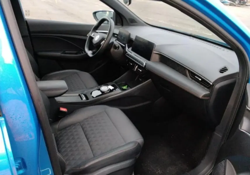 Vue intérieure côté passager avant de la MG3 1.5 Hybrid+ 195 Luxury bleu Como, avec sièges tissu/similicuir noirs et tableau de bord moderne.
