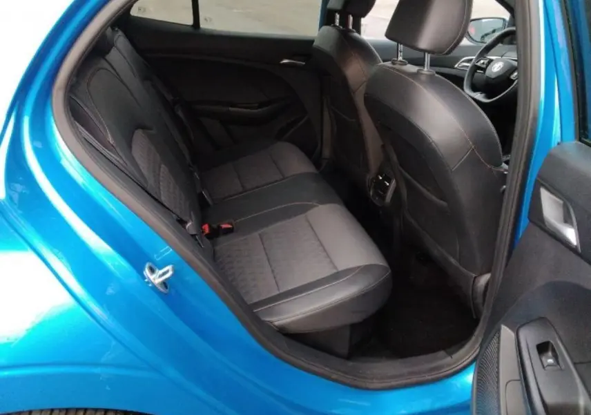 Vue intérieure côté arrière gauche d'une MG3 1.5 Hybrid+ 195 Luxury bleu Como, montrant les sièges arrière en tissu et similicuir noirs.