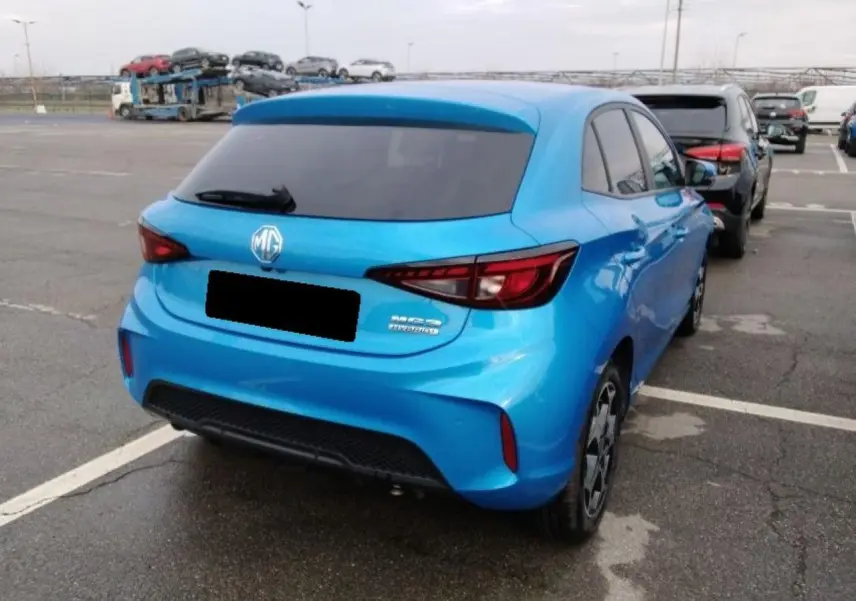 Vue 3/4 arrière droite d'une MG3 1.5 Hybrid+ 195 Luxury bleu Como avec vitres arrière surteintées sur parking.