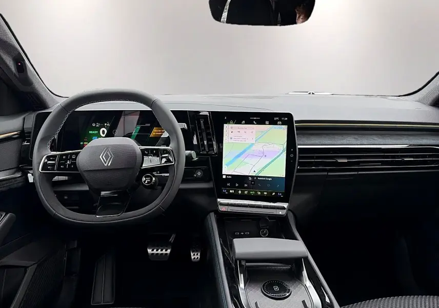 Vue intérieure avant du Renault Austral gris schiste, avec volant multifonction et grand écran tactile central affichant la navigation.