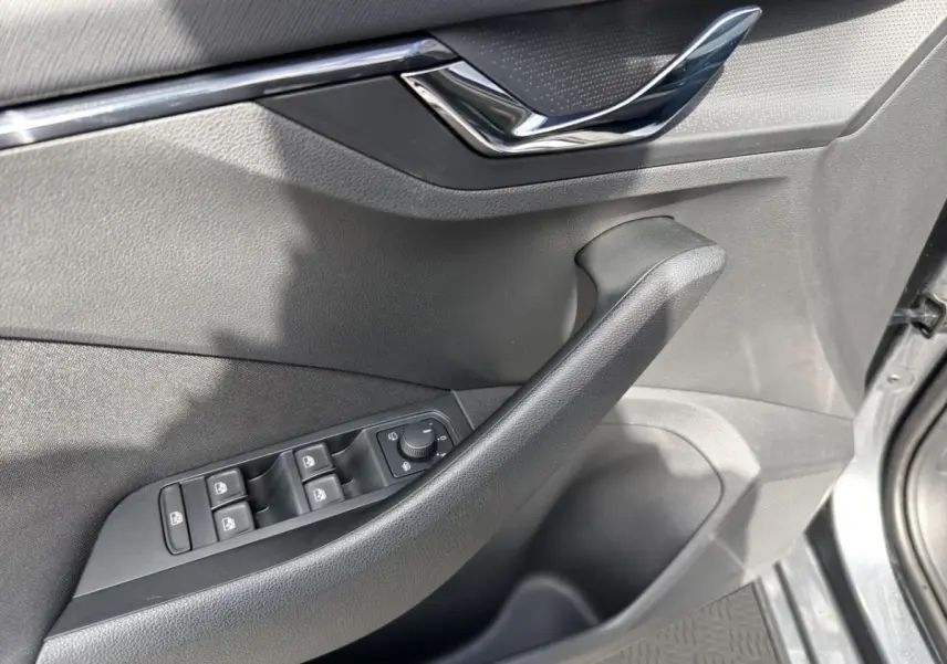 Détail de la porte côté conducteur de la Skoda Scala gris foncé avec commandes électriques des vitres et rétroviseurs.