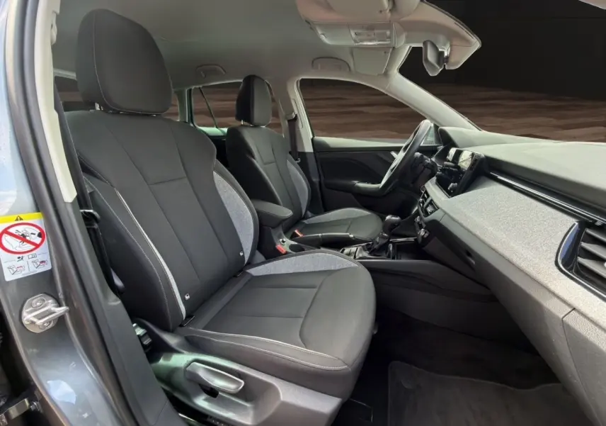 Intérieur de la Skoda Scala gris foncé vu côté conducteur, montrant sièges avant et tableau de bord moderne.