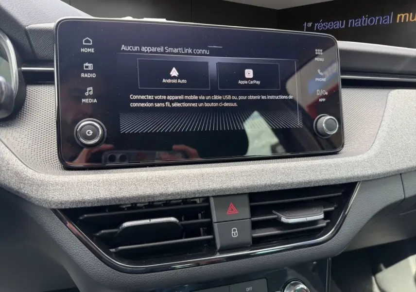 Gros plan sur l’écran tactile central et la console de bord grise de la Skoda Scala 2025, affichant Android Auto et Apple CarPlay.
