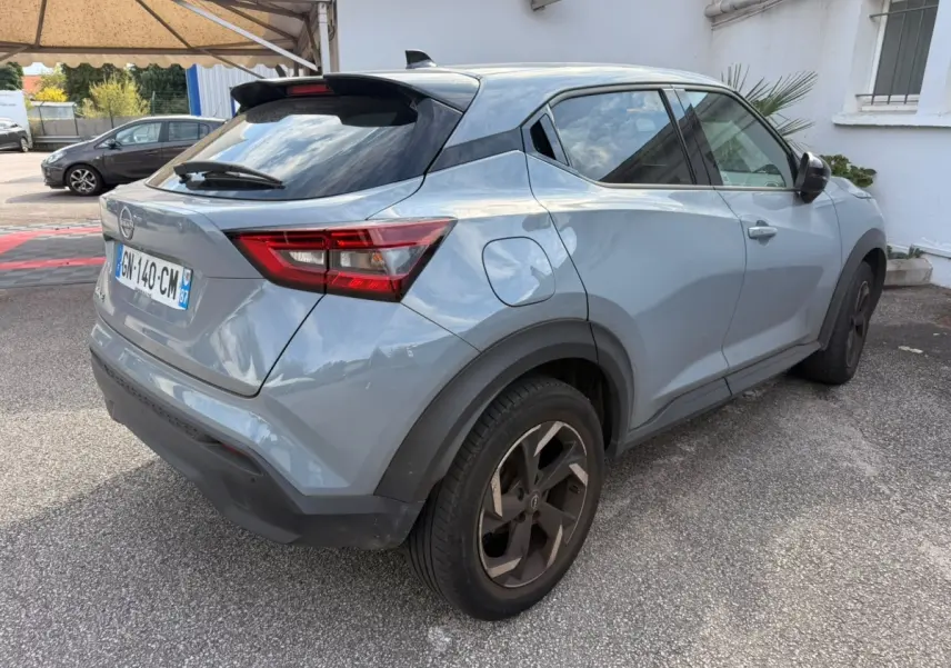 Nissan Juke gris clair vu de profil côté gauche, avec jantes noires et toit noir contrastant.