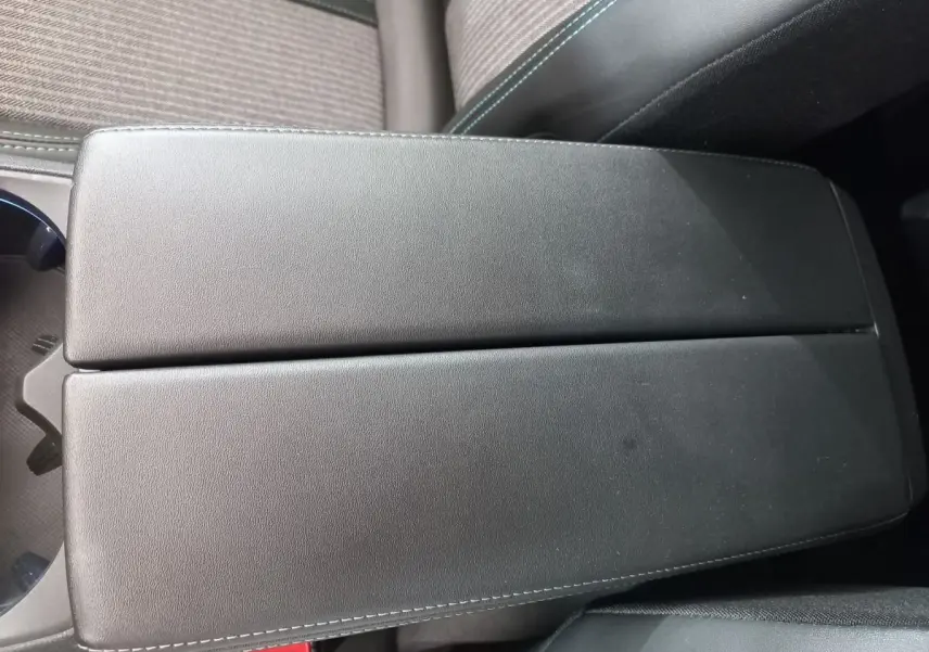 Accoudoir central noir en cuir avec surpiqûres blanches dans l'habitacle du Peugeot 5008 gris foncé, version 2021.