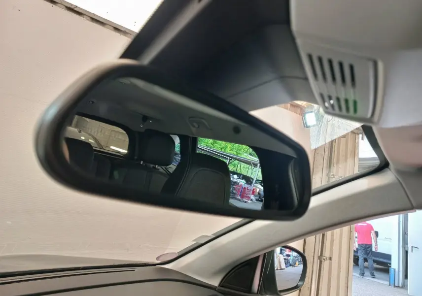 Rétroviseur intérieur montrant les sièges arrière noirs du Peugeot 5008 gris foncé, vue côté conducteur depuis l'avant.