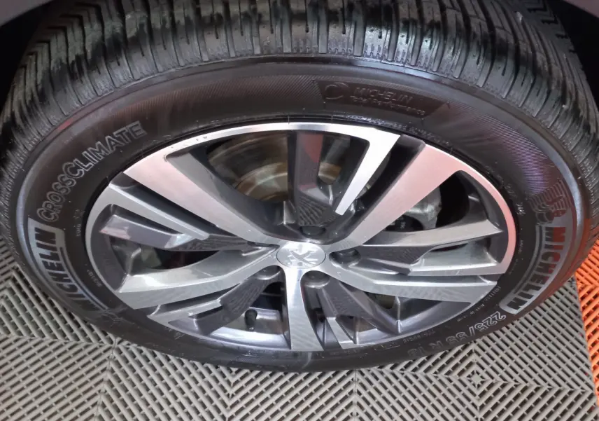Gros plan sur la jante alliage et pneu Michelin CrossClimate du Peugeot 5008 gris foncé, détail de la roue avant.