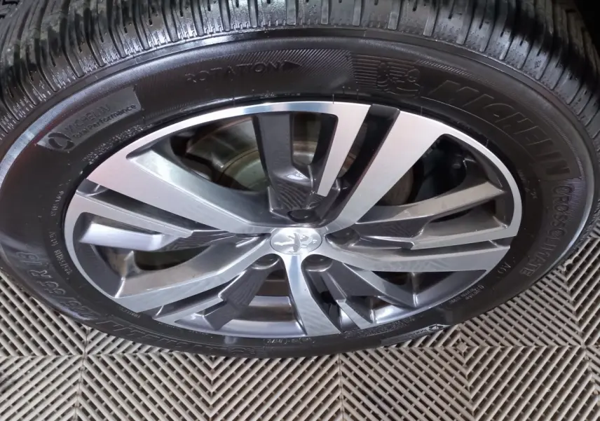 Gros plan sur la jante alliage argentée et noire du Peugeot 5008 gris foncé, pneu Michelin CrossClimate visible.