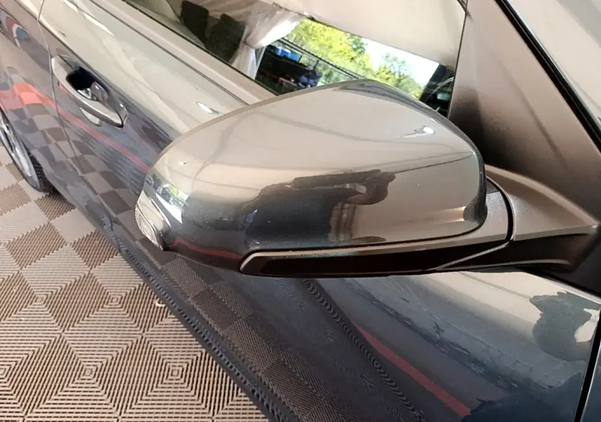 Gros plan sur le rétroviseur droit rabattable électriquement d’un Hyundai Kona bleu électrique 2023.