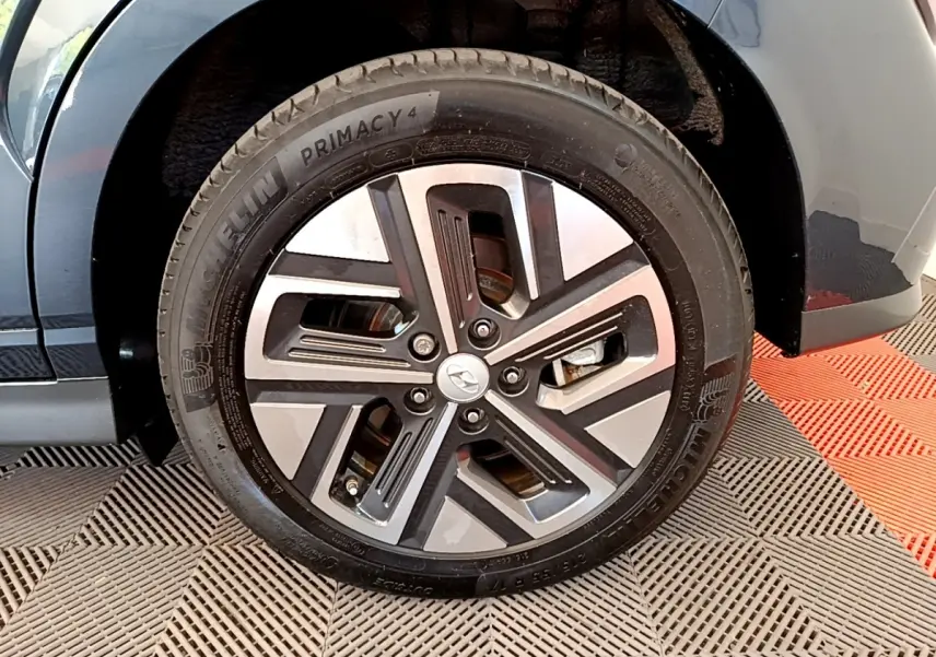 Gros plan sur la roue avant droite d’un Hyundai Kona bleu électrique, avec jante alliage moderne et pneu Michelin.