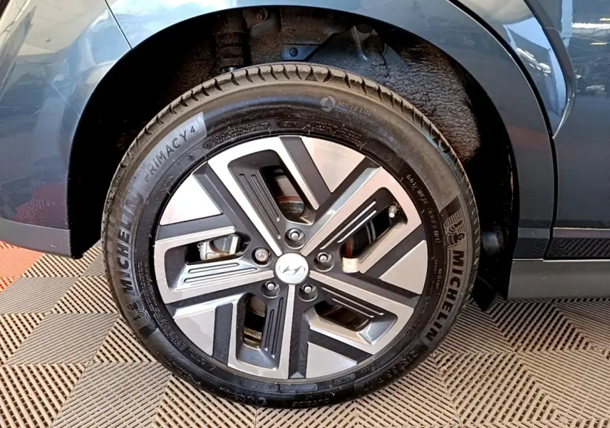 Gros plan sur la roue avant gauche de la Hyundai Kona électrique bleue, avec jante alliage et pneu Michelin.