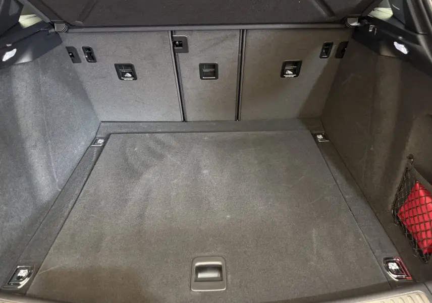 Vue intérieure du coffre gris foncé du Porsche Macan 3.0 S 2019, montrant un espace propre et bien organisé avec filet latéral.
