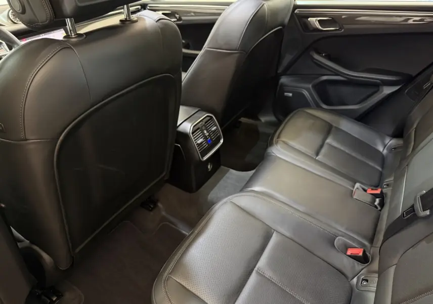Vue intérieure arrière du Porsche Macan 3.0 S 2019, sièges en cuir noir et console centrale avec ventilation.