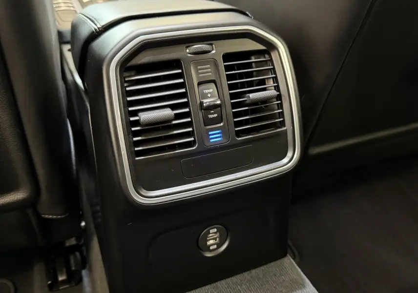 Détail des aérateurs arrière avec commande de température et prises USB dans un Porsche Macan 3.0 S gris foncé.