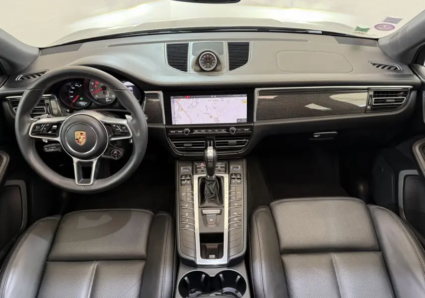 Vue intérieure frontale du tableau de bord et volant cuir alu du Porsche Macan 3.0 S gris foncé de 2019.