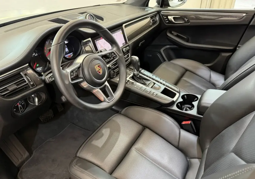 Vue intérieure côté conducteur du Porsche Macan 3.0 S 2019, montrant volant cuir alu, tableau de bord et sièges gris foncé.