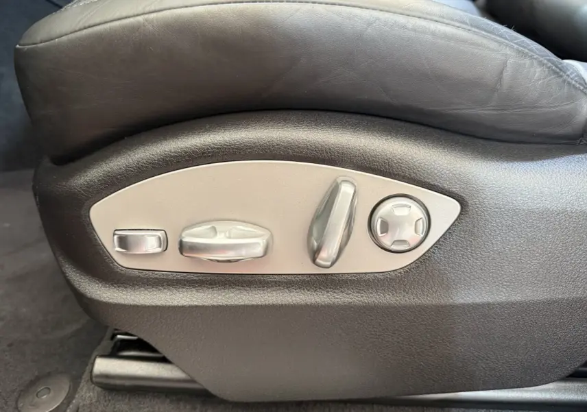 Gros plan sur les commandes de réglage électrique du siège en cuir noir du Porsche Macan 3.0 S gris foncé.
