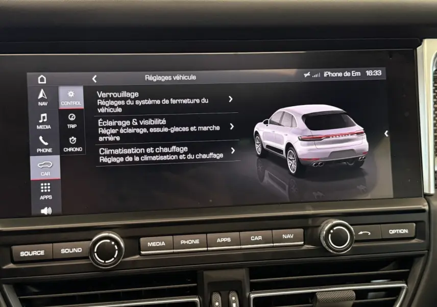 Écran tactile du tableau de bord affichant les réglages véhicule et une illustration 3/4 arrière d’un Porsche Macan gris clair.