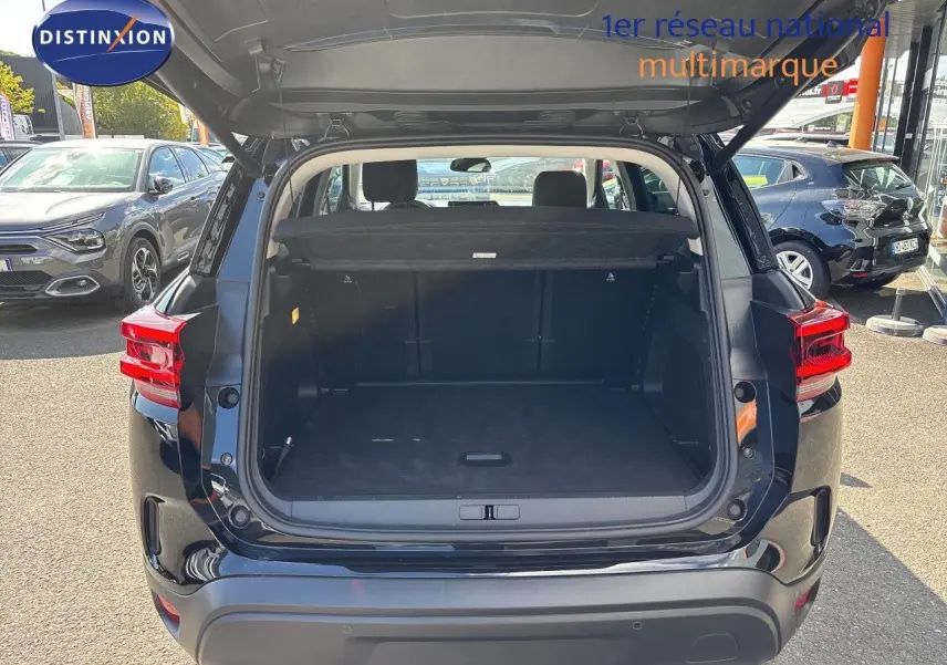 Coffre ouvert d’un Citroën C5 Aircross noir Perla Nera, vue arrière montrant l’espace de chargement vide.