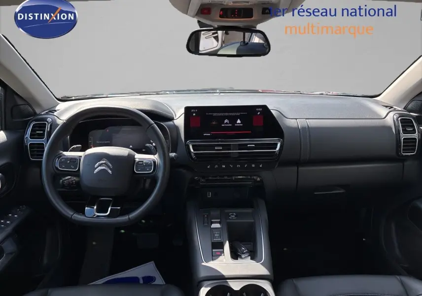 Vue intérieure avant du Citroën C5 Aircross noir, tableau de bord moderne avec écran tactile central et volant multifonction.