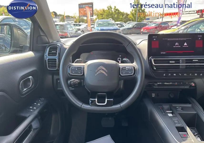 Vue intérieure frontale du poste de conduite noir du Citroën C5 Aircross 2025 avec écran tactile et volant multifonction.
