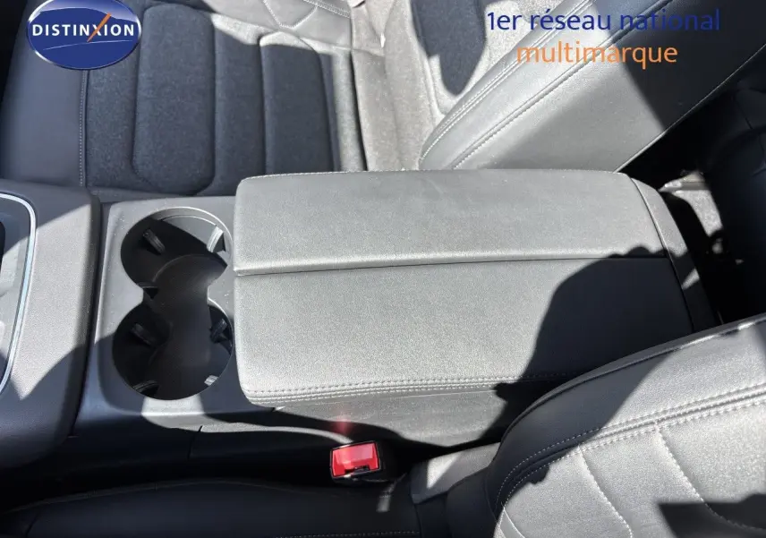 Vue rapprochée de l'accoudoir central et des sièges noirs en tissu et cuir du Citroën C5 Aircross 2025.