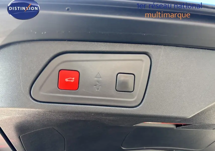 Gros plan sur le bouton rouge d'ouverture du coffre dans l'habitacle du Citroën C5 Aircross noir Perla Nera.