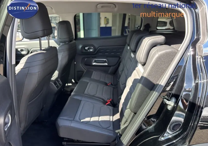Vue intérieure côté droit montrant la banquette arrière en tissu et cuir du Citroën C5 Aircross noir Perla Nera 2025.