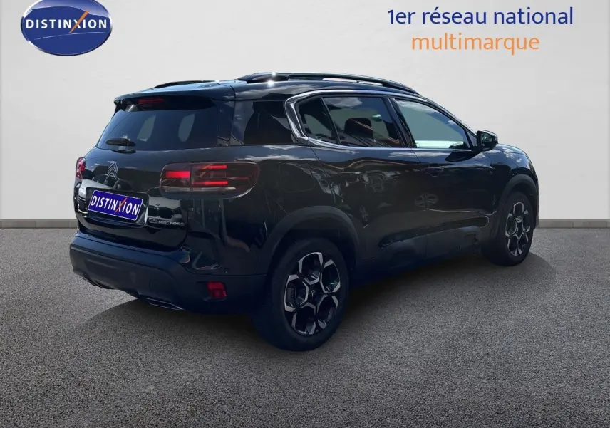 Vue 3/4 arrière droite d'un Citroën C5 Aircross noir Perla Nera métallisé avec jantes noires et toit panoramique.