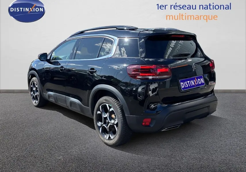 Citroën C5 Aircross noir Perla Nera, vue 3/4 arrière droit, jantes alliage et barres de toit visibles.