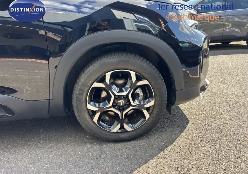 Gros plan sur la roue avant droite du Citroën C5 Aircross noir Perla Nera, mettant en valeur la jante au design moderne.
