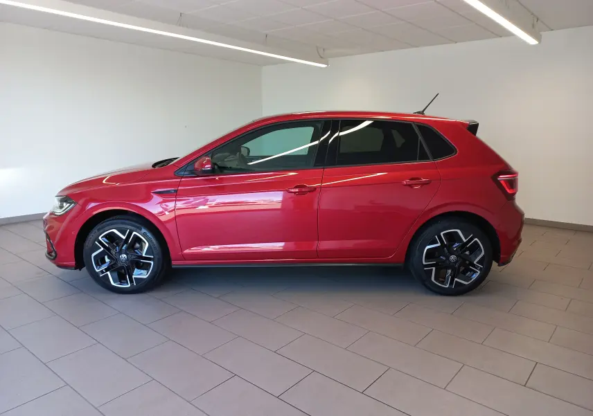 Vue de profil côté gauche d'une Volkswagen Polo Rouge Roi 2025 R-Line Edition avec jantes noires et détails sportifs.