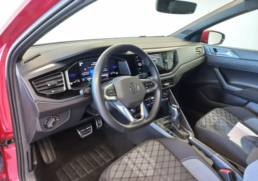 Vue intérieure côté conducteur de la Volkswagen Polo Rouge Roi 2025, avec tableau de bord numérique et volant multifonction.