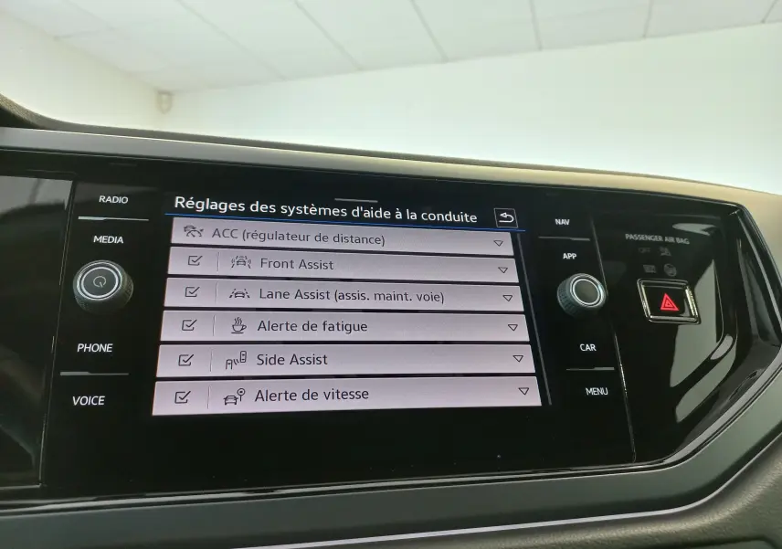 Écran tactile central de la Volkswagen Polo 2025 Rouge Roi, affichant les réglages des aides à la conduite.