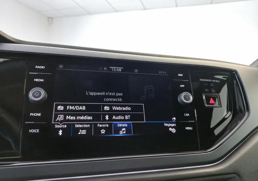 Écran tactile central du Volkswagen Polo 2025 affichant les options audio avec boutons physiques autour, ambiance intérieure noire.