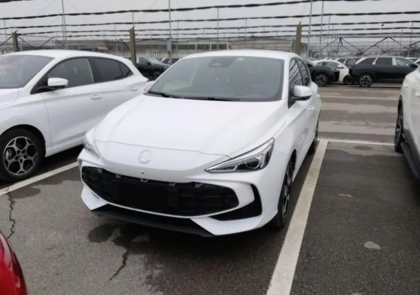 MG3 blanc Dover en 3/4 avant droit sur parking, avec calandre noire et phares LED distinctifs.