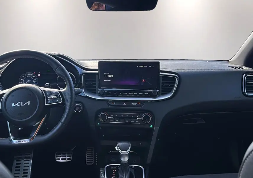 Vue intérieure frontale du tableau de bord noir du KIA Xceed 2024 avec écran tactile et volant multifonction.