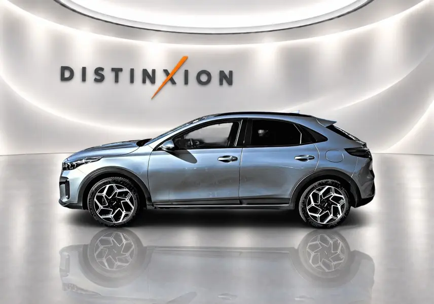 KIA Xceed gris en profil droit dans un showroom lumineux avec jantes alu au design hexagonal.