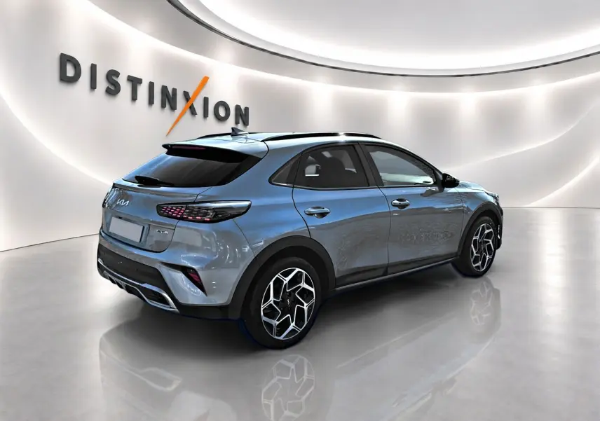 KIA Xceed gris 3/4 arrière droit en showroom avec jantes alu et vitres surteintées.
