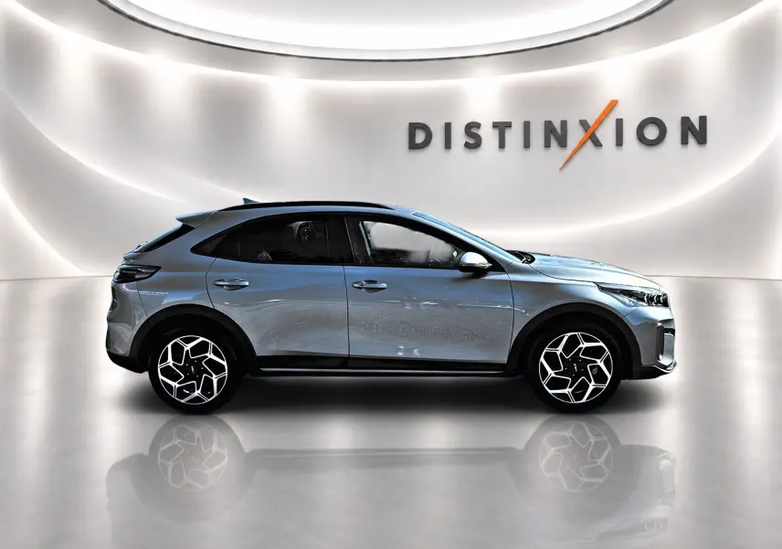 KIA Xceed gris en profil droit dans un showroom avec jantes alu au design moderne et toit noir contrasté.