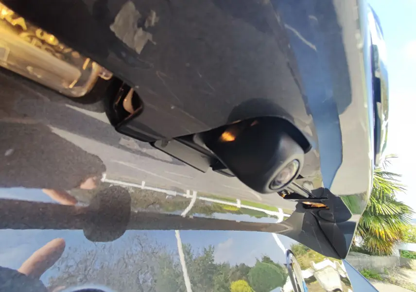 Gros plan sur la caméra de recul sous le hayon arrière d'une Mazda2 gris foncé 2024.