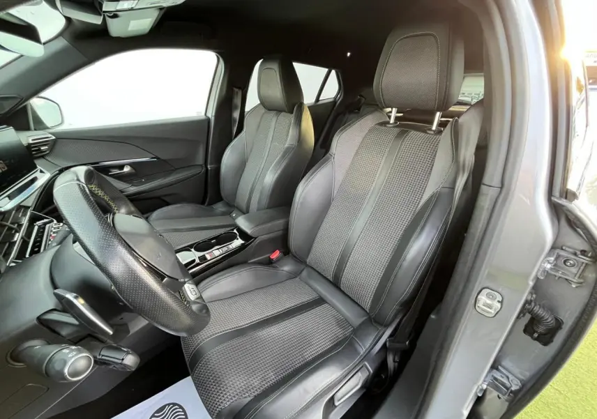 Intérieur avant droit du Peugeot 2008 gris Artense, sièges sport en cuir et tissu avec surpiqûres contrastées.