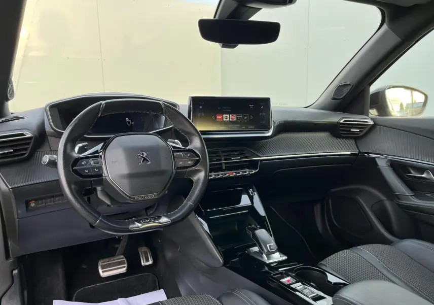 Intérieur avant du Peugeot 2008 II 1.2 PureTech 130 gris, tableau de bord moderne avec écran tactile et volant compact.