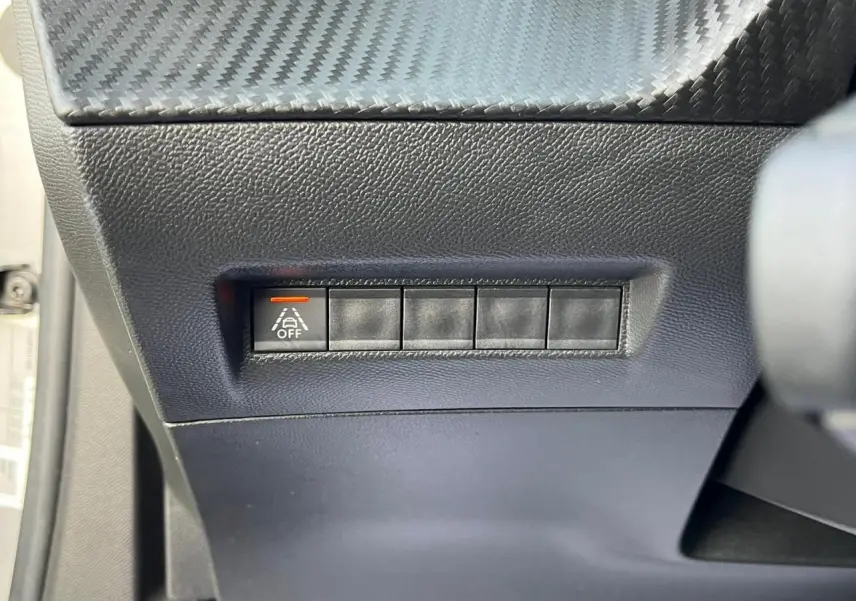 Bouton de désactivation de l'assistance au maintien de voie sur le tableau de bord d'une Peugeot 2008 gris Artense toit noir.