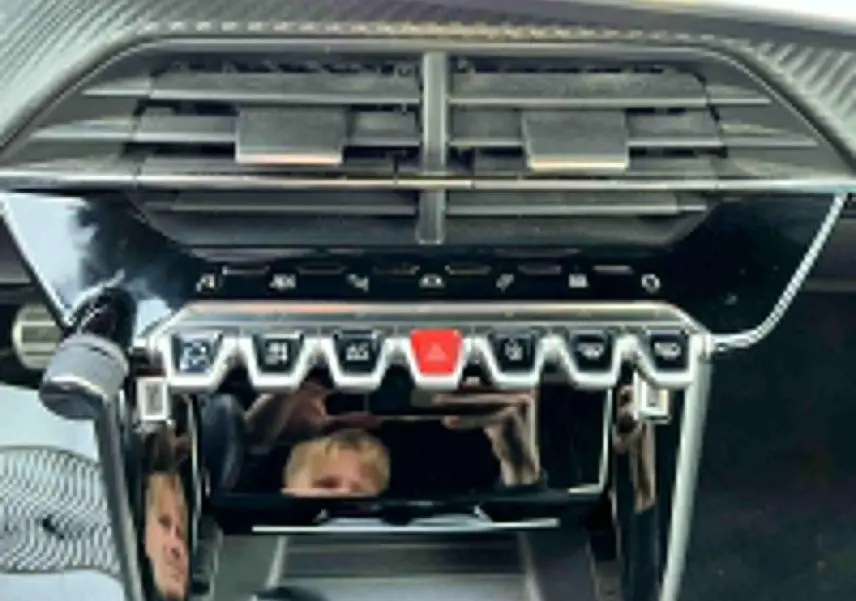 Vue rapprochée de la console centrale du Peugeot 2008 II avec ses commandes piano et aérateurs noirs brillants.